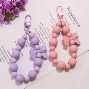 1pc 핑크 진주 활 키 체인 전화 안티-분실 매는 밧줄 키 짧은 손목 펜던트 다채로운 마카롱 구슬 펜던트 여성 휴대용 체인