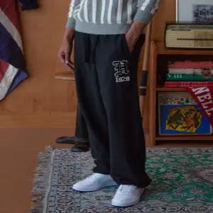 헤지스 남성 24FW [로잉클럽] 로잉 그래픽 와이드 스웨트팬츠 HZPA4D002BK