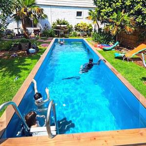 현대적인 디자인과 내장된 계단을 갖춘 지하 수영장 위의 뒷마당 준비 컨테이너 세련된 강철 프레임