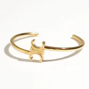 CELINE  25FW TRIOMPHE ASYMMETRIC CUFF IN BRASS WITH GOLD FINISH (460PQ6BRA 35OR) (트리옹프 애