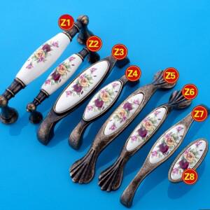 골동품 가구는 빈티지 서랍을 처리합니다. 세라믹 문 손잡이를 당깁니다. 중국 꽃 찬장 캐비닛용