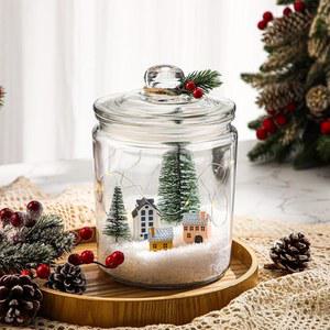선물과 장식을 위한 레드 베리 눈 크리스마스 트리로 불을 밝힌 키트킨 쿠키 병 선물