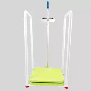 노인이 서서 체중 증가를 측정하는 데 도움을 주며 팔걸이가 있는 전자 저울로 클리닉 병원 학교