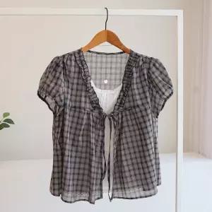 [잇수다] 나쿠오 리본 프릴 체크 레이어드 반팔 블라우스