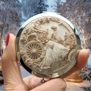 TEMU 크리스마스용 2D 평면 휴대용 메이크업 거울 1개, 레이스 웨딩 드레스를 입은 여성이 빈티지 마차에 앉아 있는 장면이 담겨져 있으며, 조각 장식된 꽃무늬 디자인이 장식되어 있어 휴일 선물로 이상적입니다.