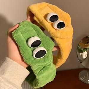 귀여운 플러시 헤어밴드, 큰 눈이 특징이며 세안 또는 마스크를 바르기 위해 머리를 묶을 때 완벽합니다. 부드러운 섬유로 제작된 트렌디한 디자인으로 머리 스타일링 및 클렌징을 위한 매력적인 액세서리입니다.
