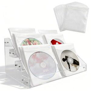 4단 투명 아크릴 캐스케이딩 CD 홀더, DVD /CD 디스플레이 스탠드, 보관 상자 및 비닐 레코드 선반. 최대 32개의 표준 케이스를 담을 수 있으며 정리 미디어 보관을 위한 20개의 /DVD 슬리브가 포함되어 있습니다.